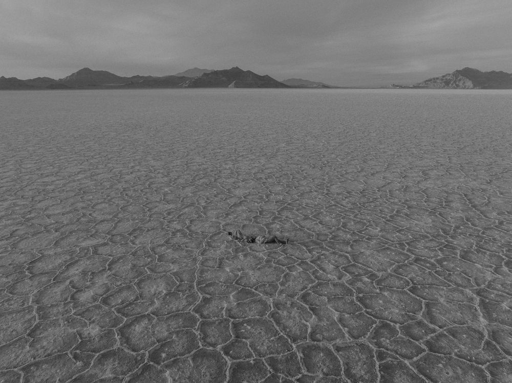 A series of aerial views showing the cracked, dry earth of a desert salt flat with mountains in the distance.