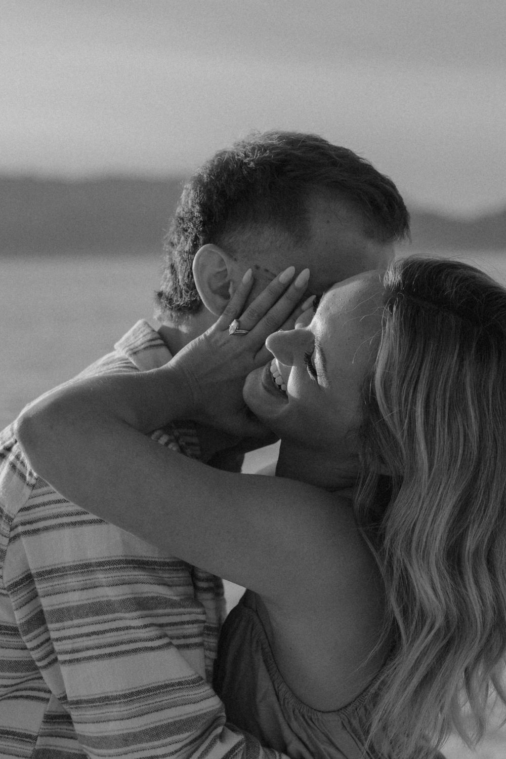 A romantic black and white sequence of a couple sharing a kiss on a beach.