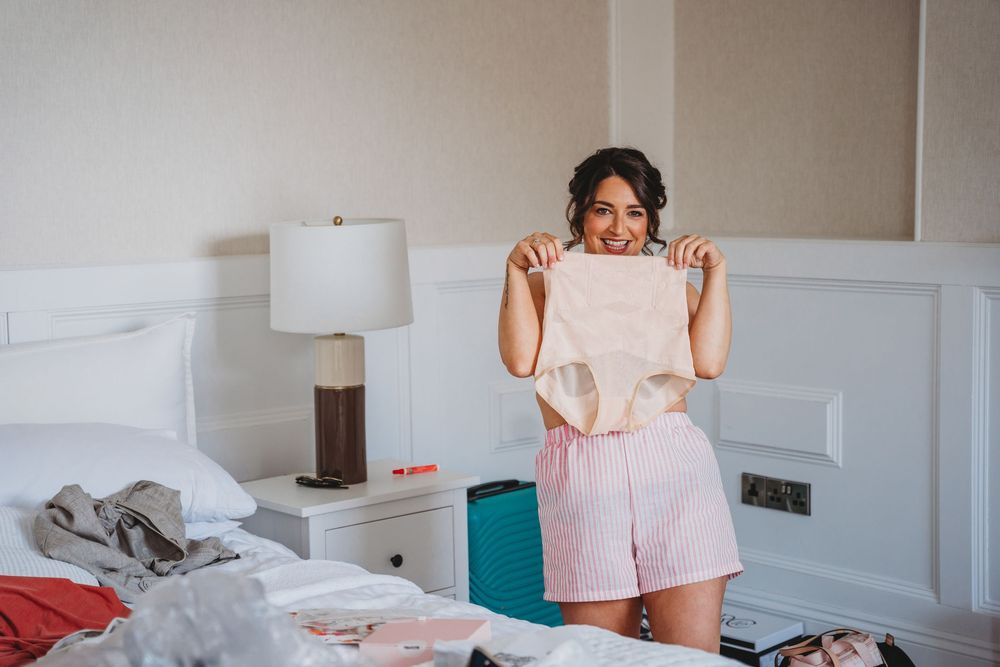 Getting ready moments captured in a bright hotel room on wedding morning.
