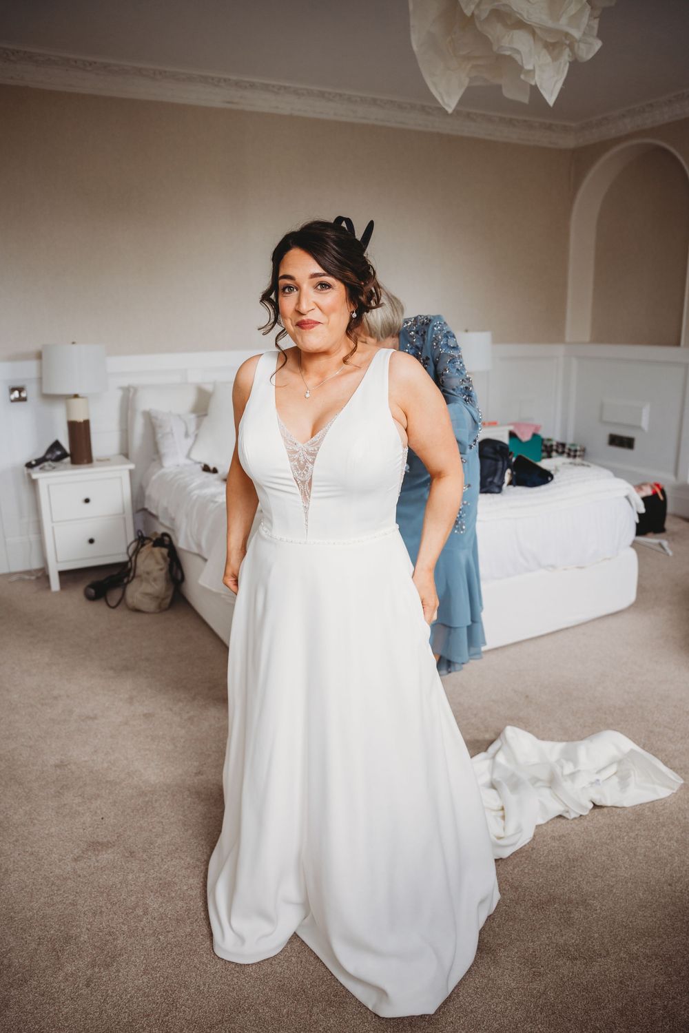Series of getting ready shots showing white wedding dress preparations in bright room.