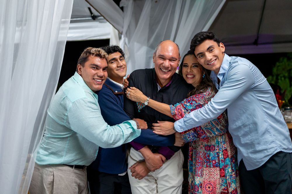 Family group hugging and smiling during outdoor celebration at night