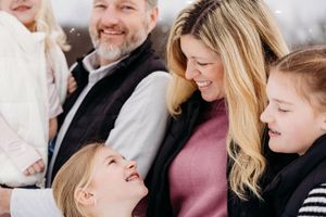 A joyful candid moment shared between family members during a winter photo session.