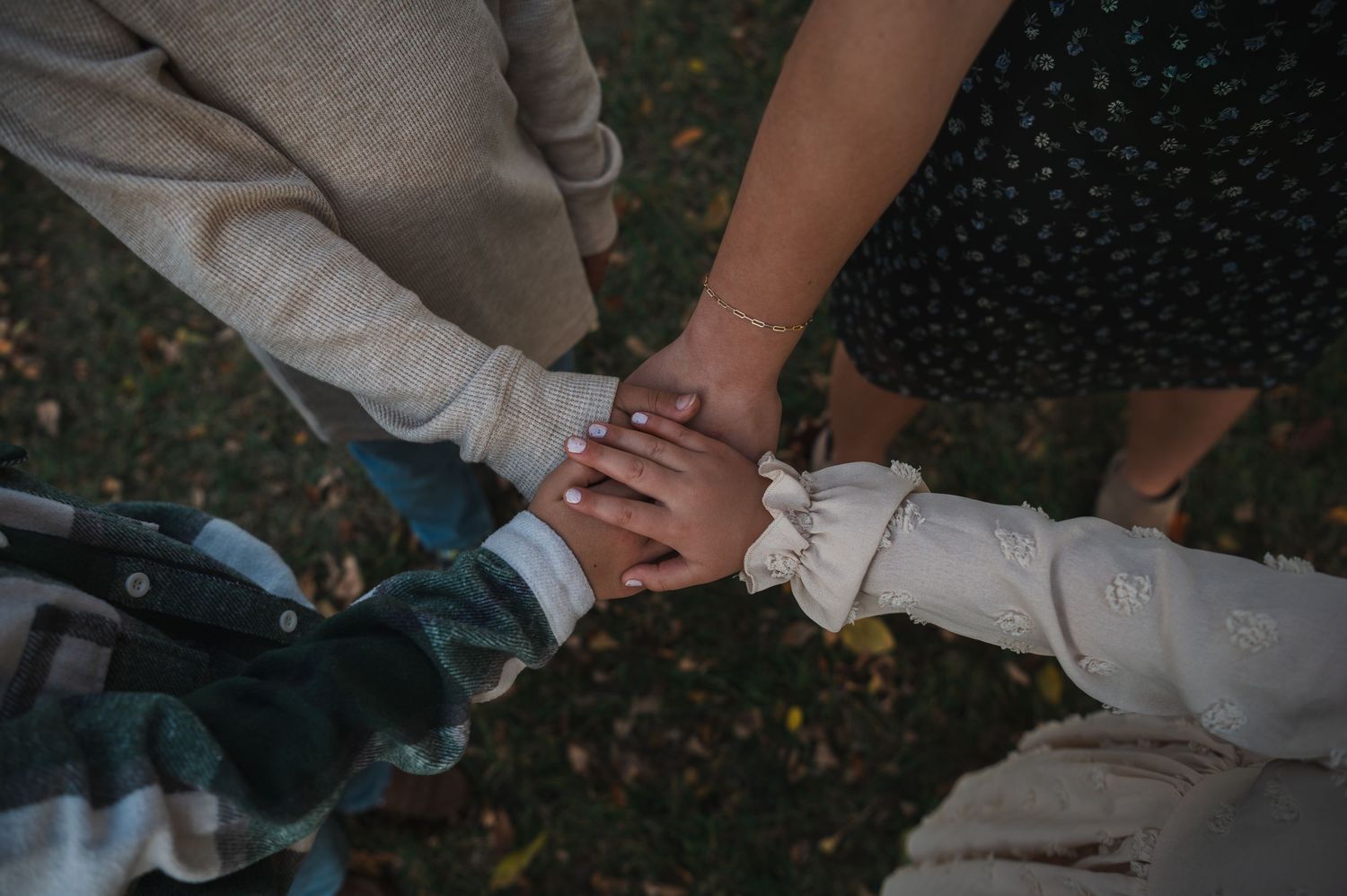 Hands clasped together intimately against a dark background.