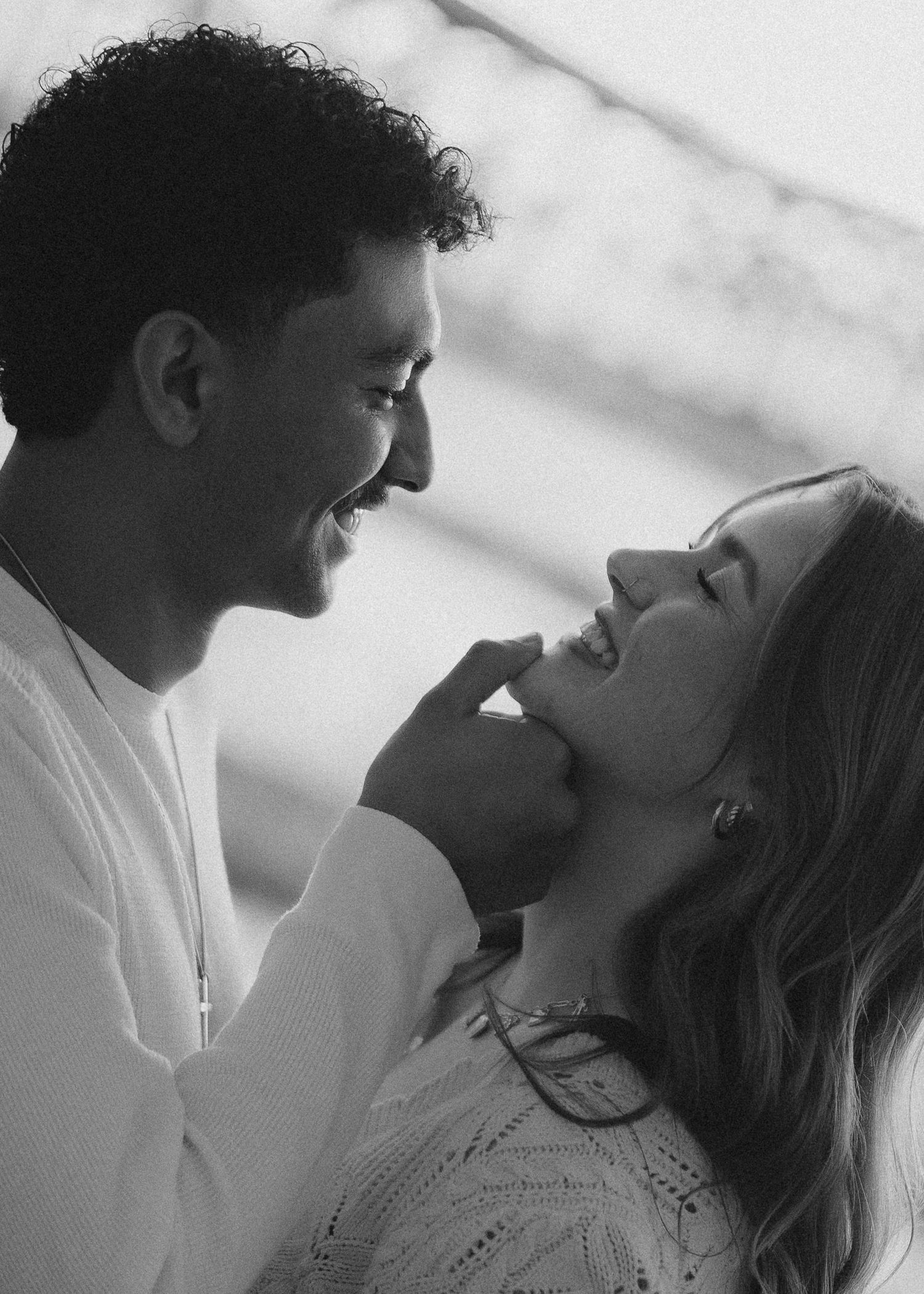 A black and white intimate portrait of a couple sharing a tender moment.