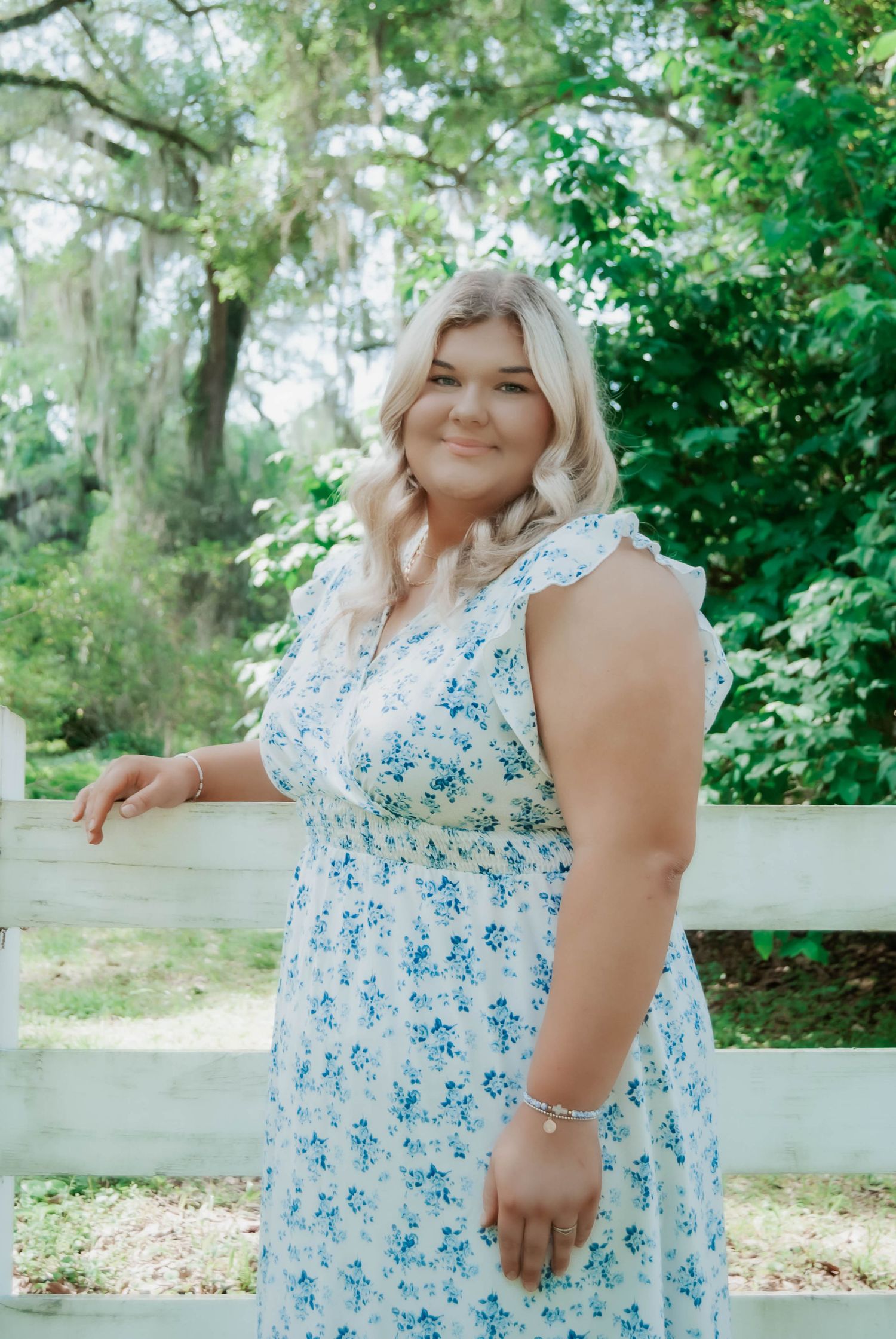 Light blue floral dress showcased in multiple poses against a lush green garden background.
