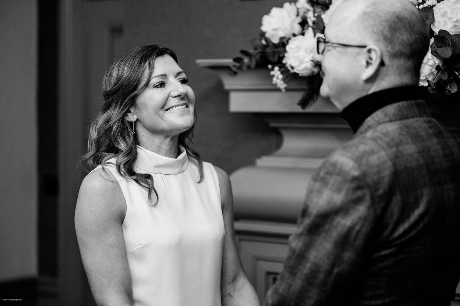 A bride and groom share joyful laughter together in a series of black and white wedding photos.
