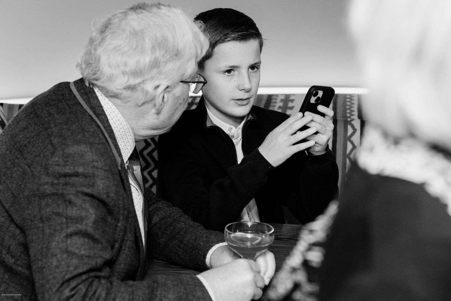 A black and white photo strip showing people in conversation at what appears to be a formal gathering or meeting.
