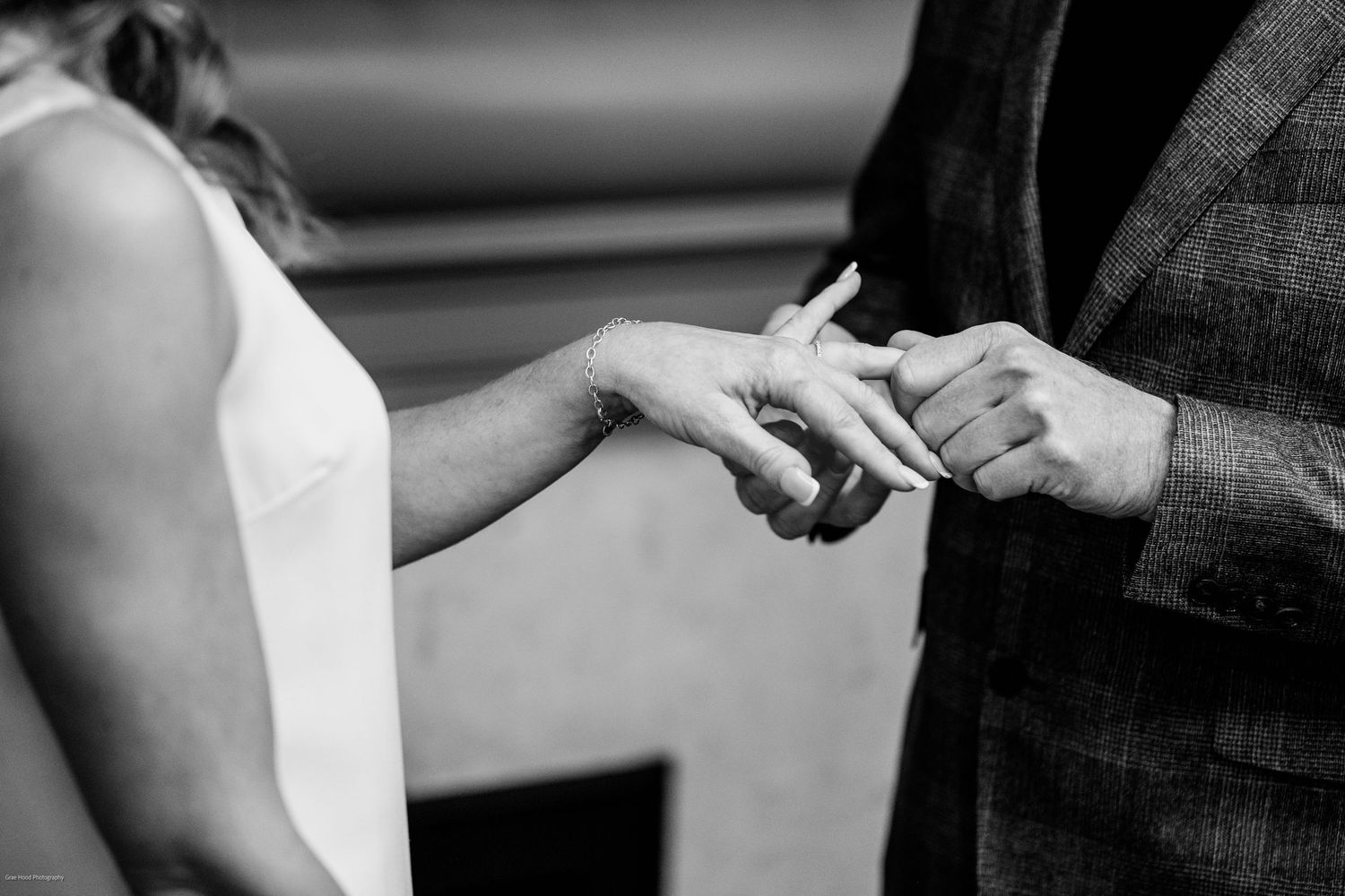 A couple holding hands during a wedding ceremony with close up shots showing their ring exchange.