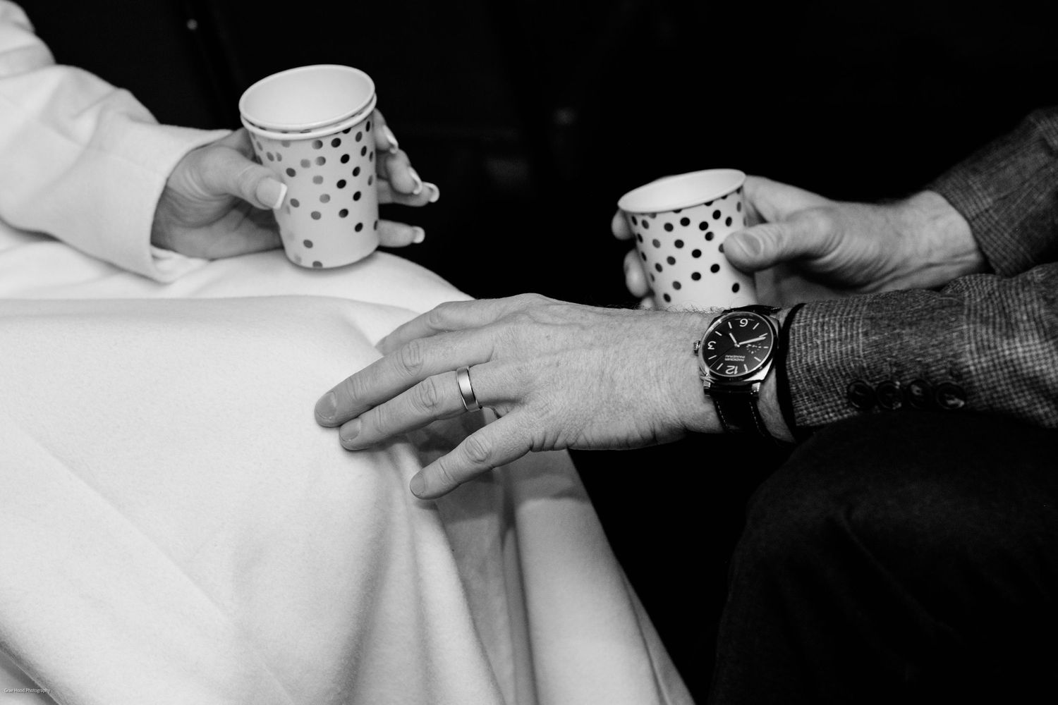 A series of black and white photos showing hands holding polka dot coffee mugs in various poses.