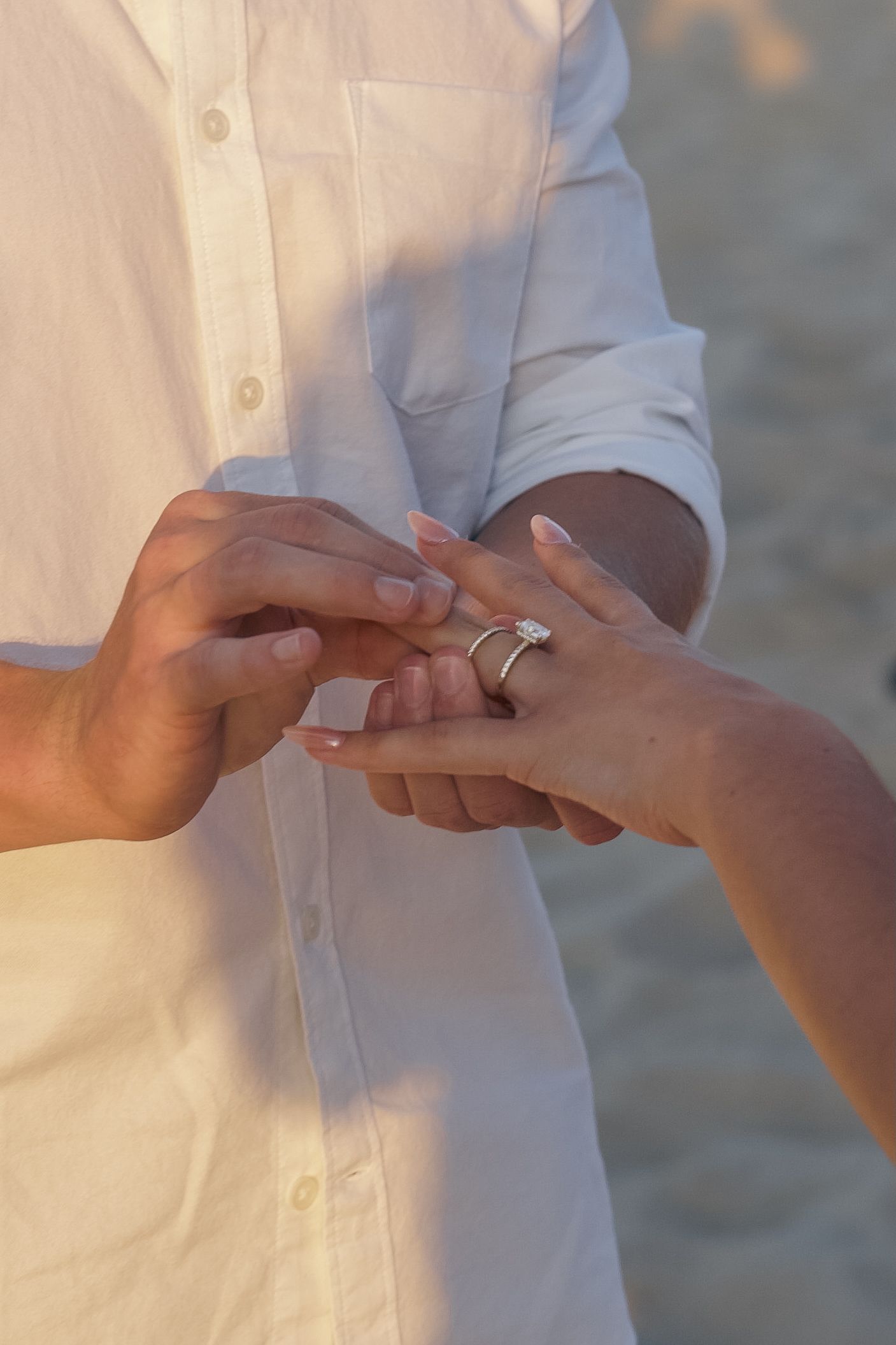 A series of photos showing hands exchanging rings during a wedding ceremony on a beach at sunset.