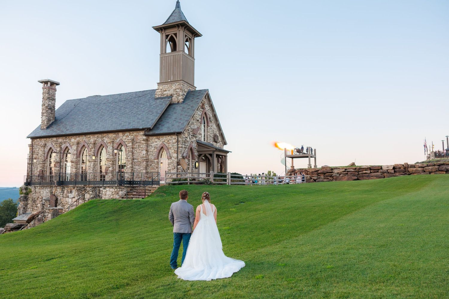 A bride and groom shares a tender moment on a scenic overlook with mountains and chapel at Top of the Rock in Ridgedale.