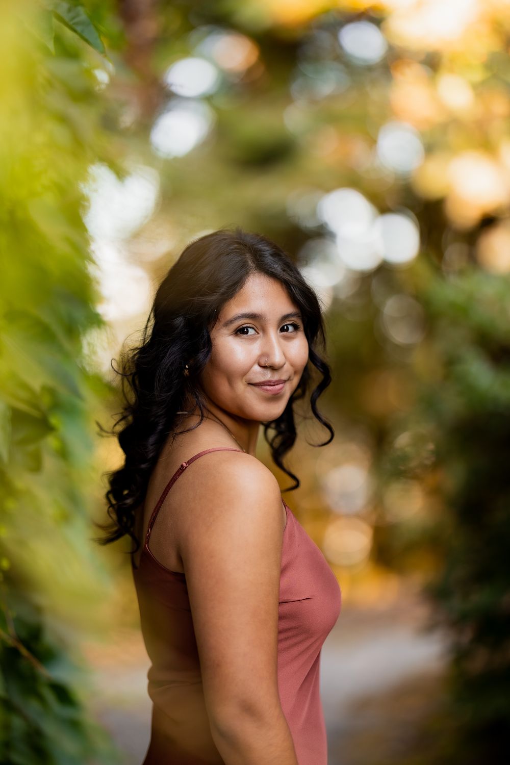 A portrait series in a garden setting with warm autumn lighting and bokeh background effects.