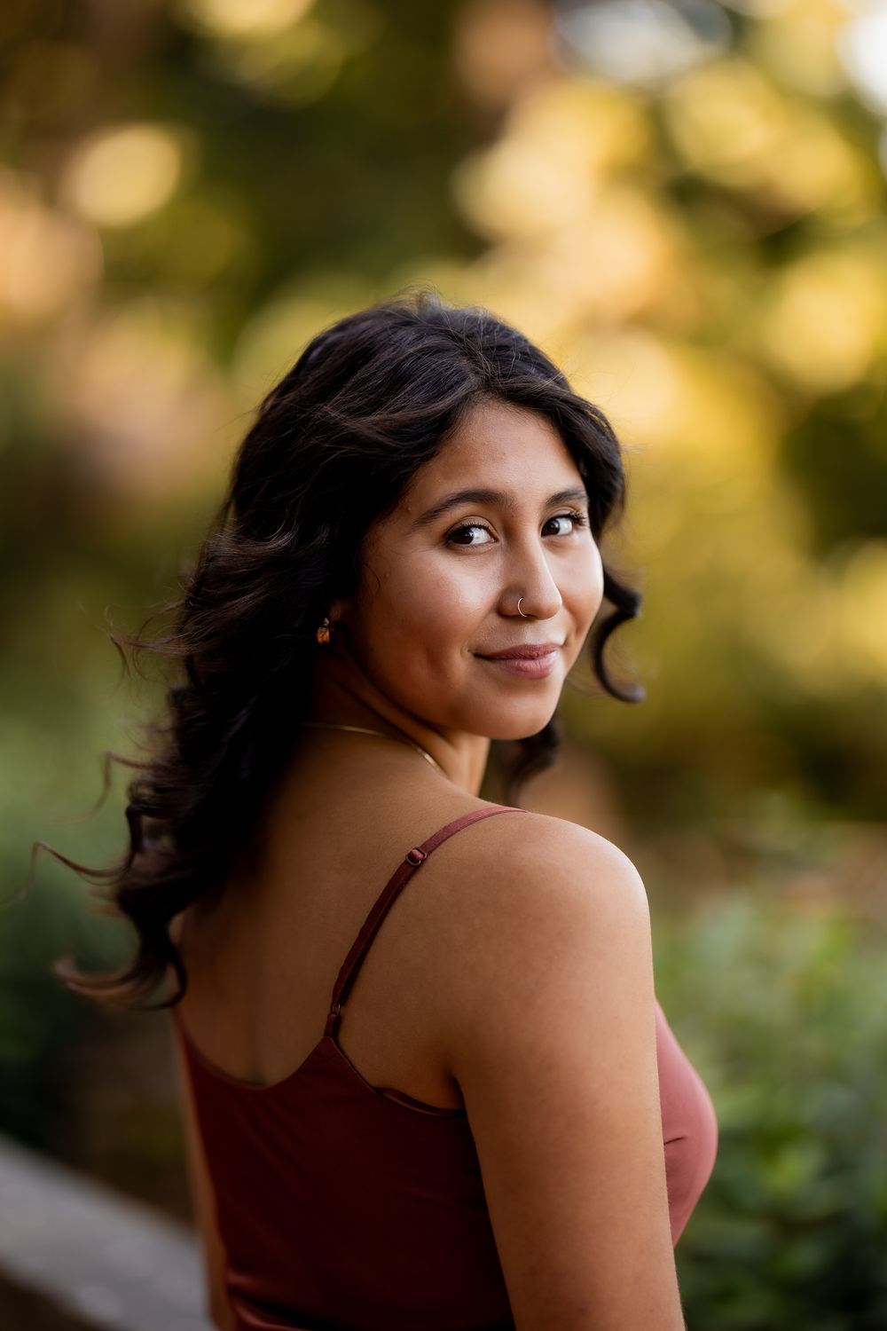 Portrait series showing playful poses against a soft-focused natural background.