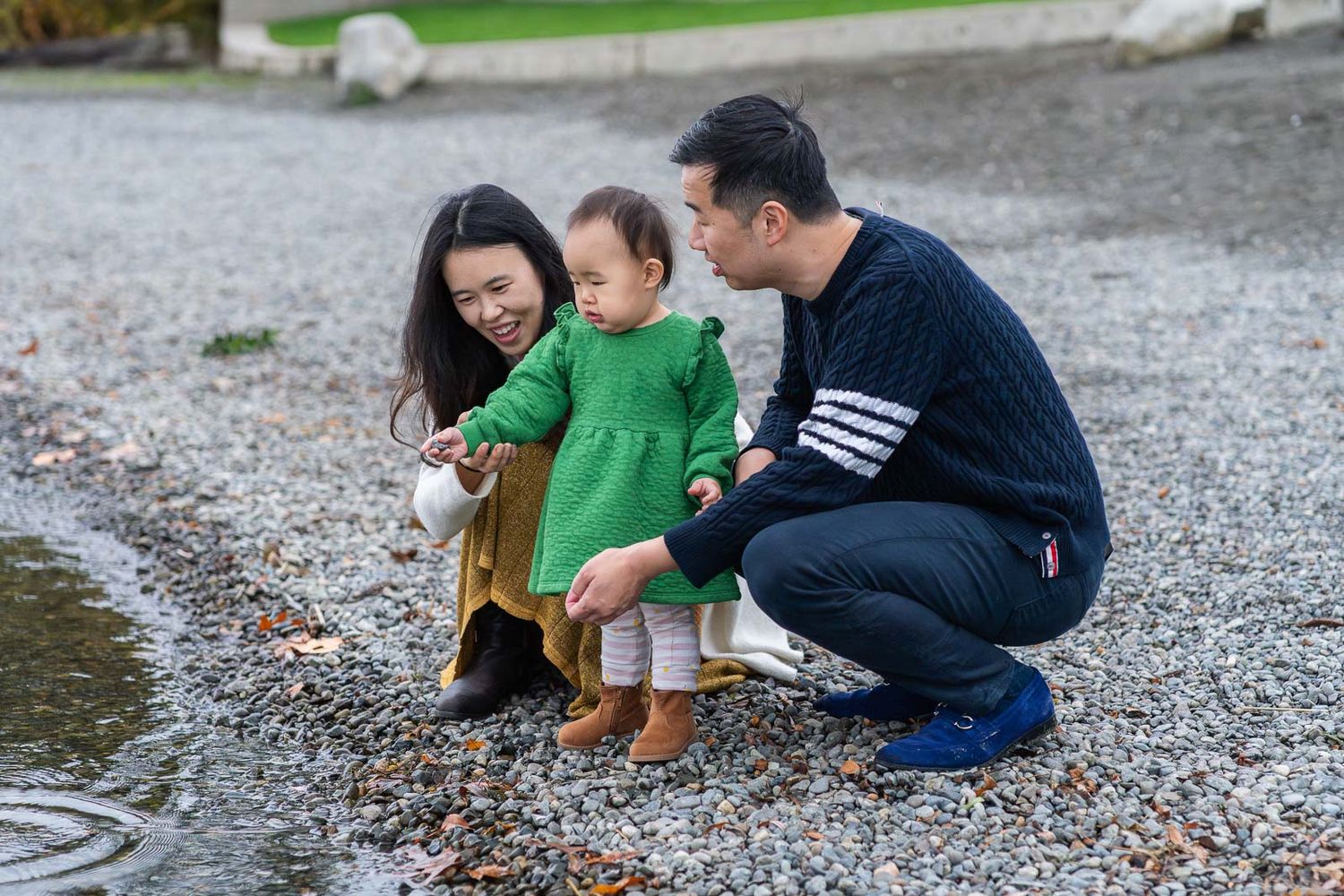 Parents playing with baby at the rocky beach in Bellevue.
