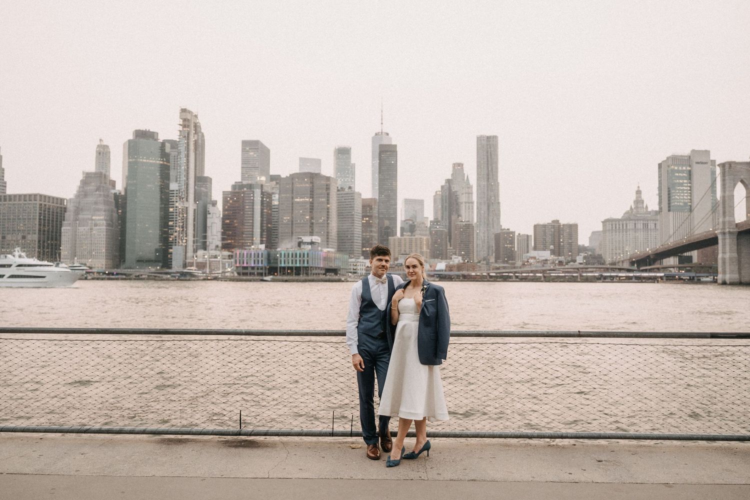 Couple walks along a foggy waterfront with the Toronto skyline visible in the distance through multiple photo frames.
