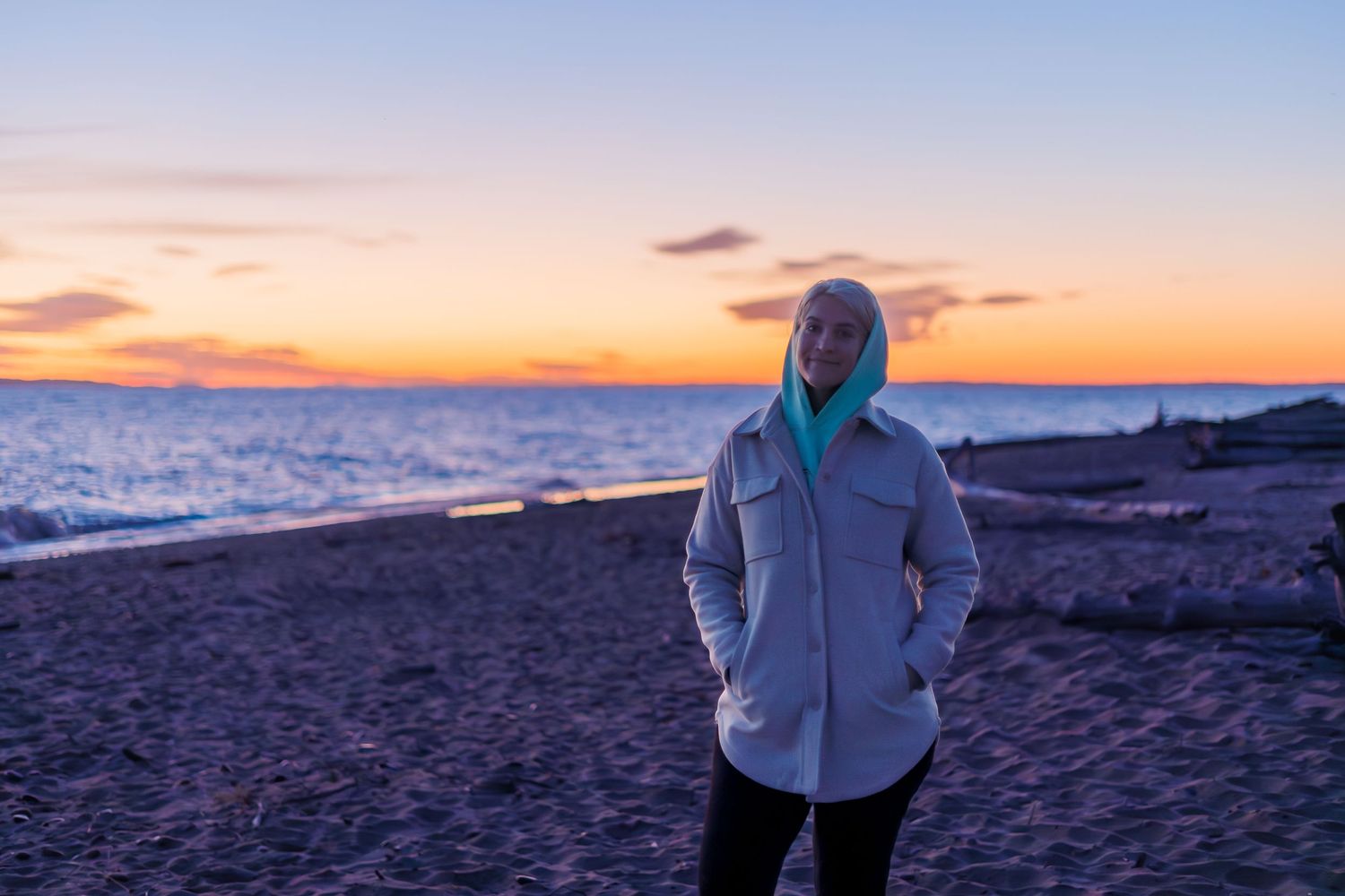 Photographer standing on the shoreline at Whitefish Bay experiencing sunrise over Lake Superior