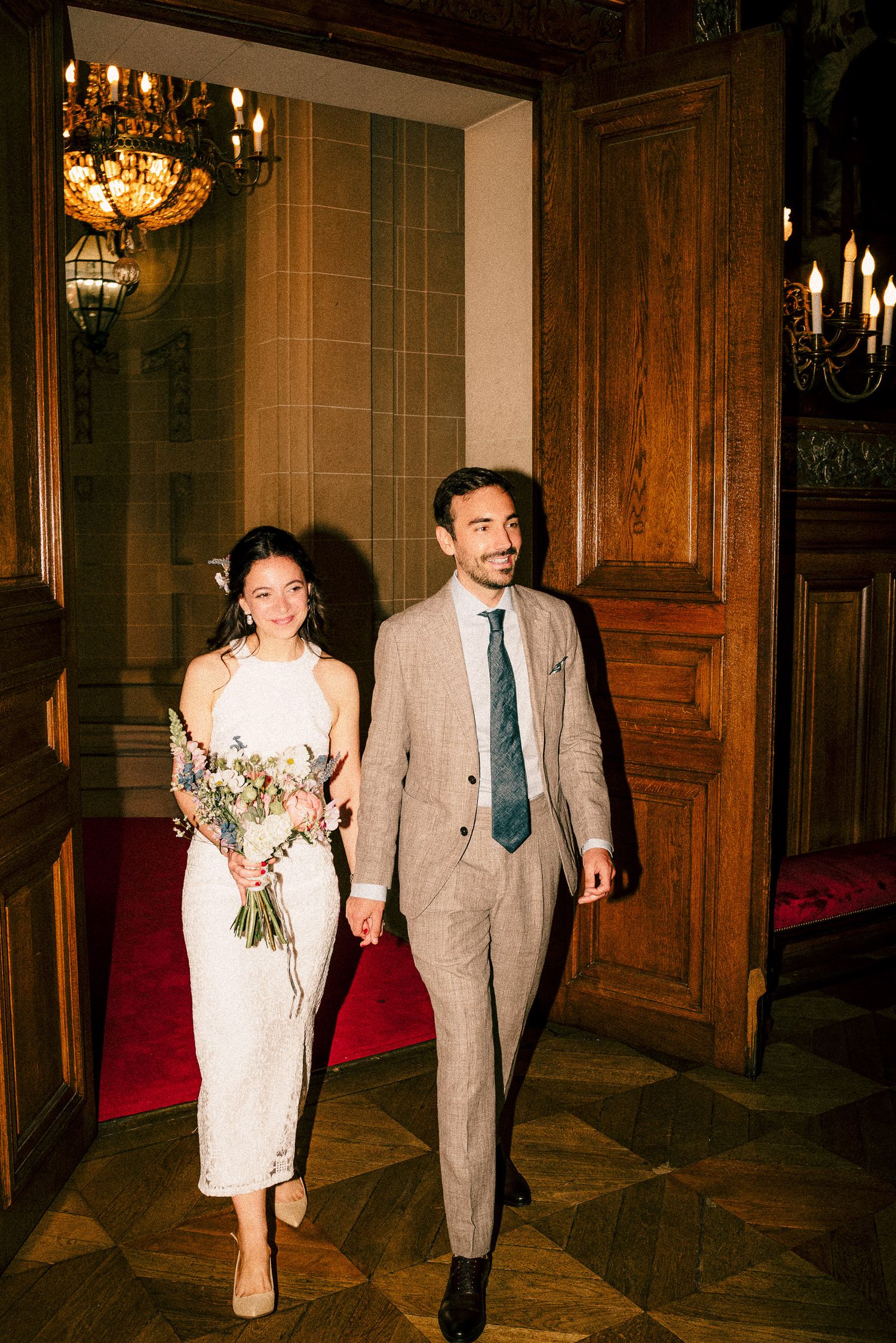 A wedding couple shares a joyful dance moment surrounded by smiling guests at their reception.