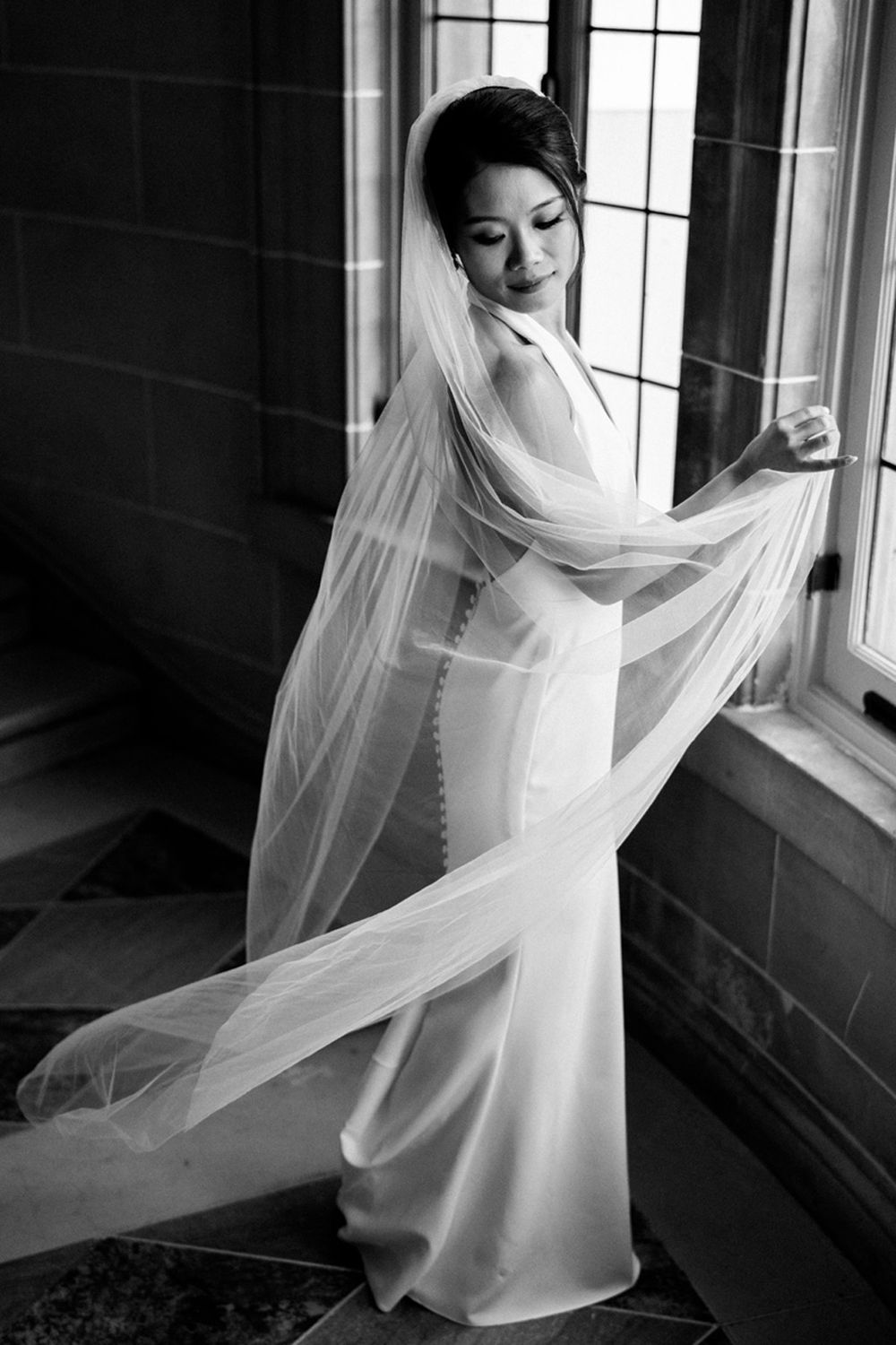Bridal portrait in black and white playing with veil at the Armour House in Lake Forest, Illinois.