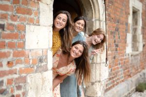 Candid portraits against rustic brick walls showing natural laughter and connection.