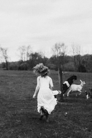 A series of black and white images showing someone running through a field in a flowing white dress.
