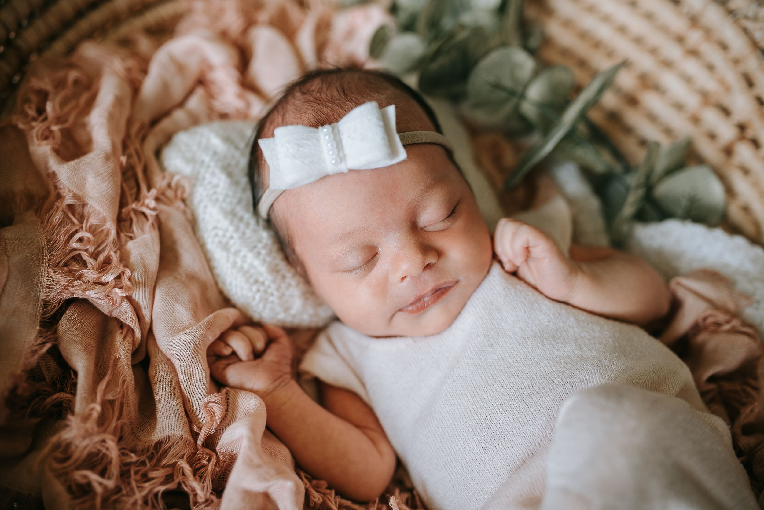 Sweet newborn sleeping peacefully on soft white textured blanket.
