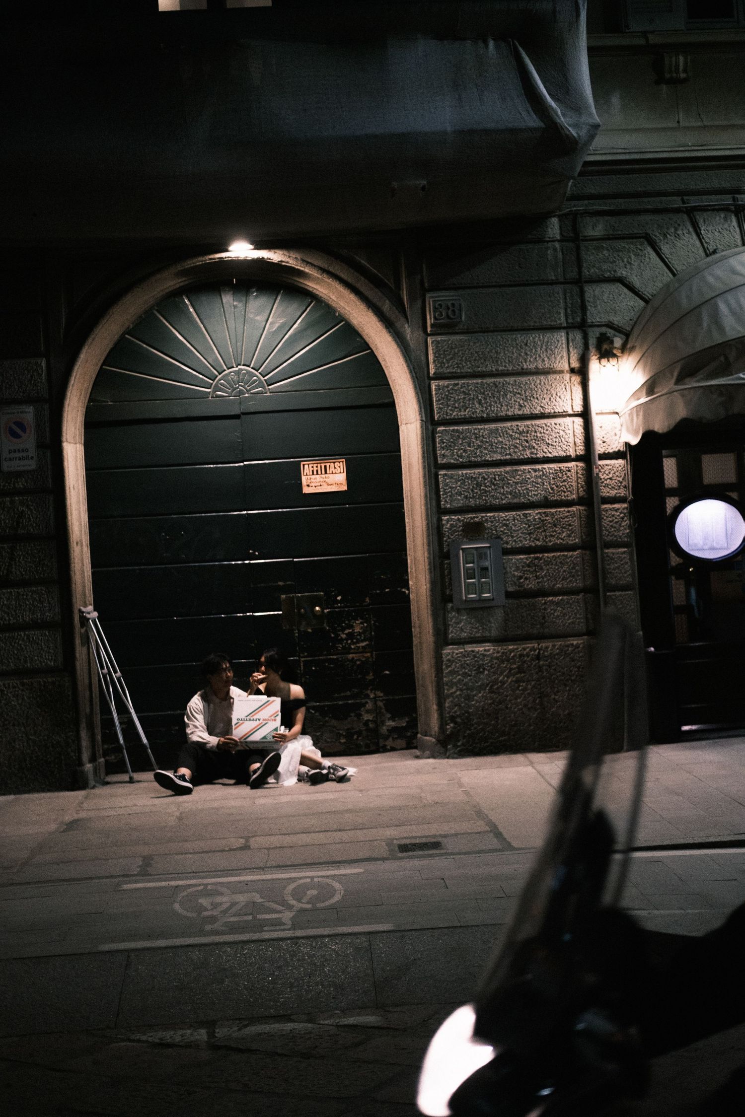 Dark urban underpass at night with dim lighting and arched architectural features creating an eerie atmosphere.