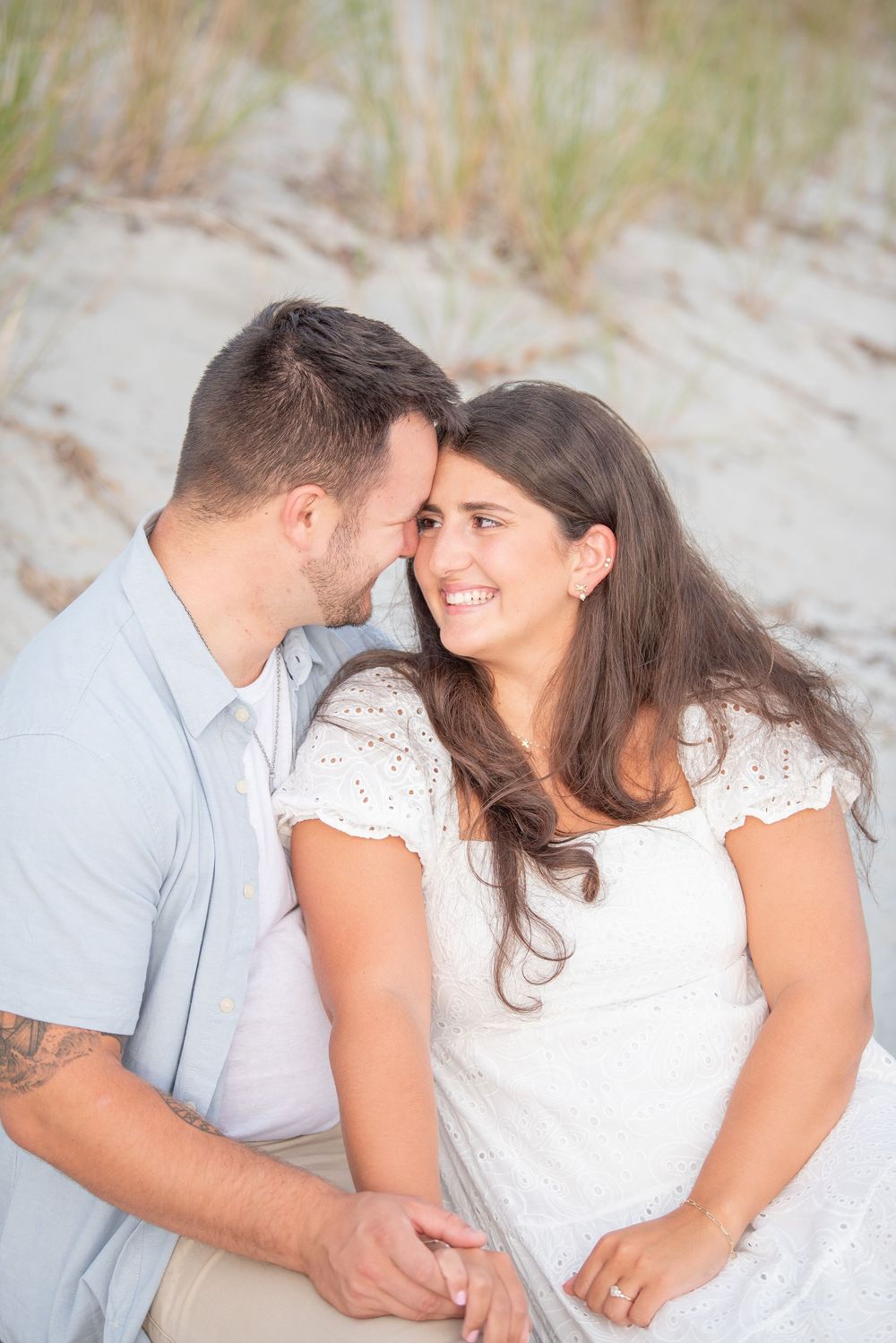 A couple shares an intimate moment during their beach engagement session.