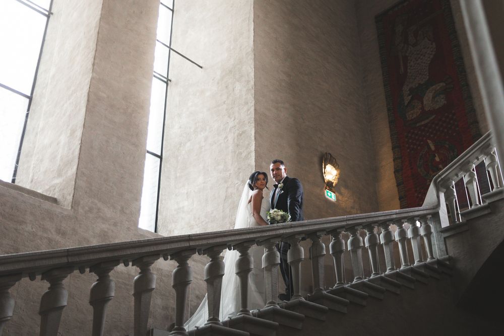 Interior view of a historic church sanctuary with vaulted ceilings, stone columns and arched windows letting in natural light.