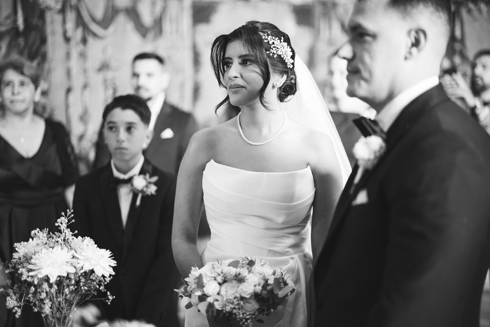 A bride and groom share their first dance at an elegant wedding reception surrounded by guests.