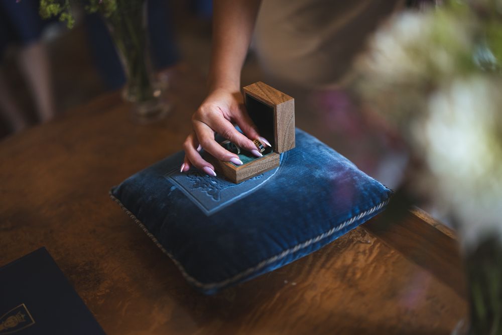 A series of steps showing how to use a grater to shred cheese onto a wooden cutting board.