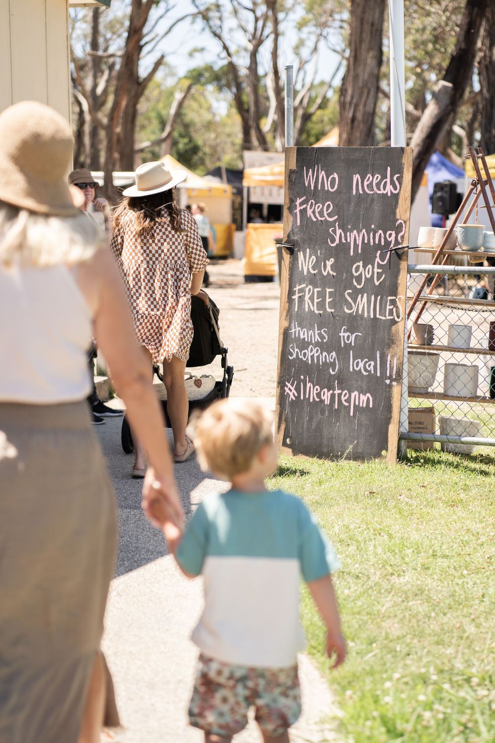 A chalkboard sign advertising free shipping deals at an outdoor market.