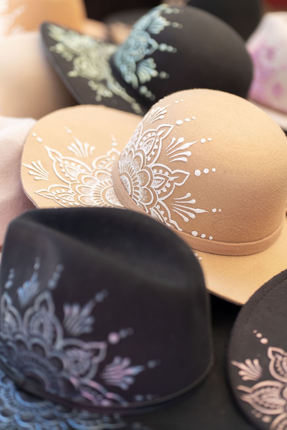 Decorative hats with intricate mandala-style patterns in black and beige colors.