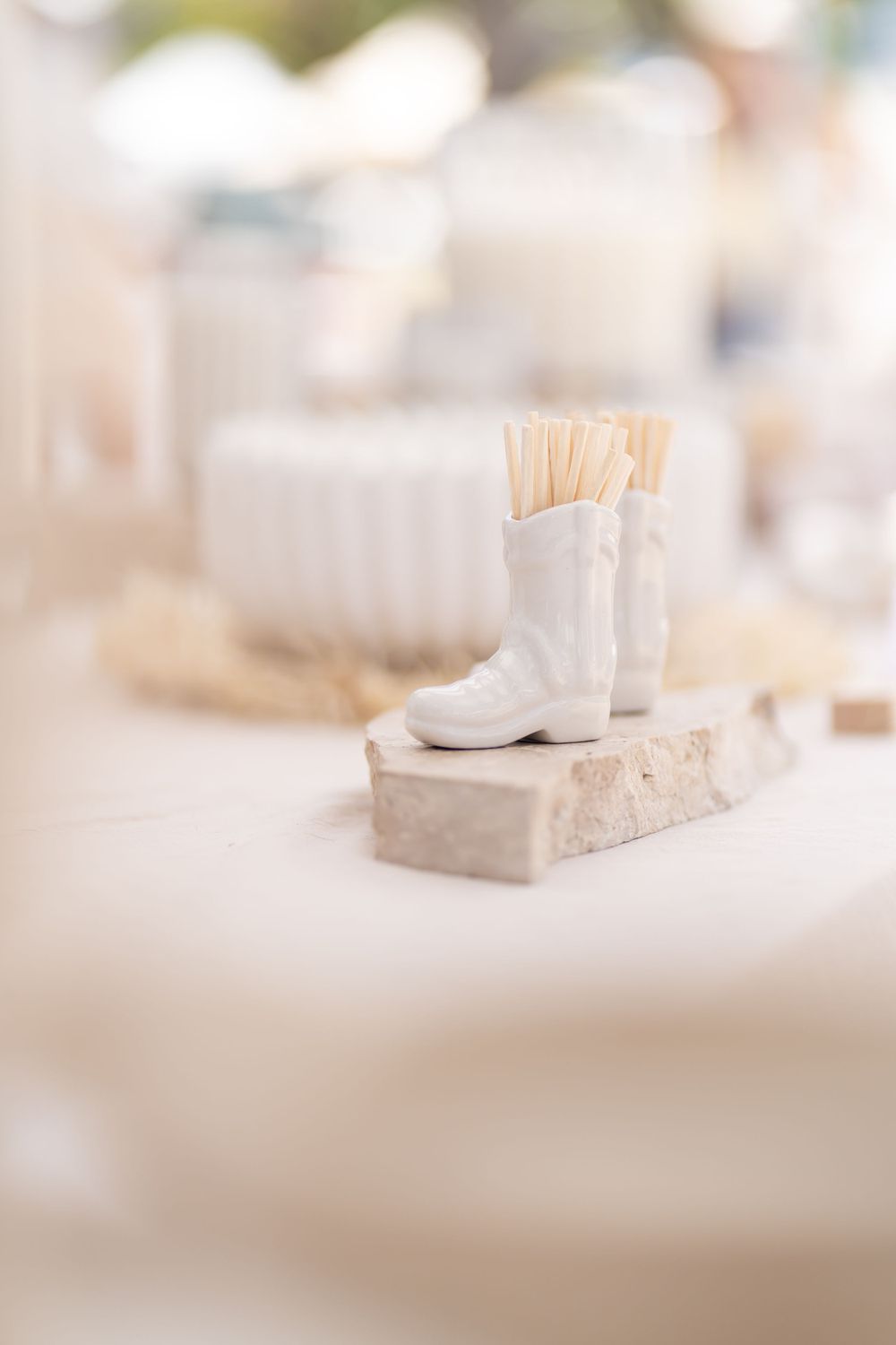 Small white ceramic boot on a stone base holds toothpicks or small decorative items.