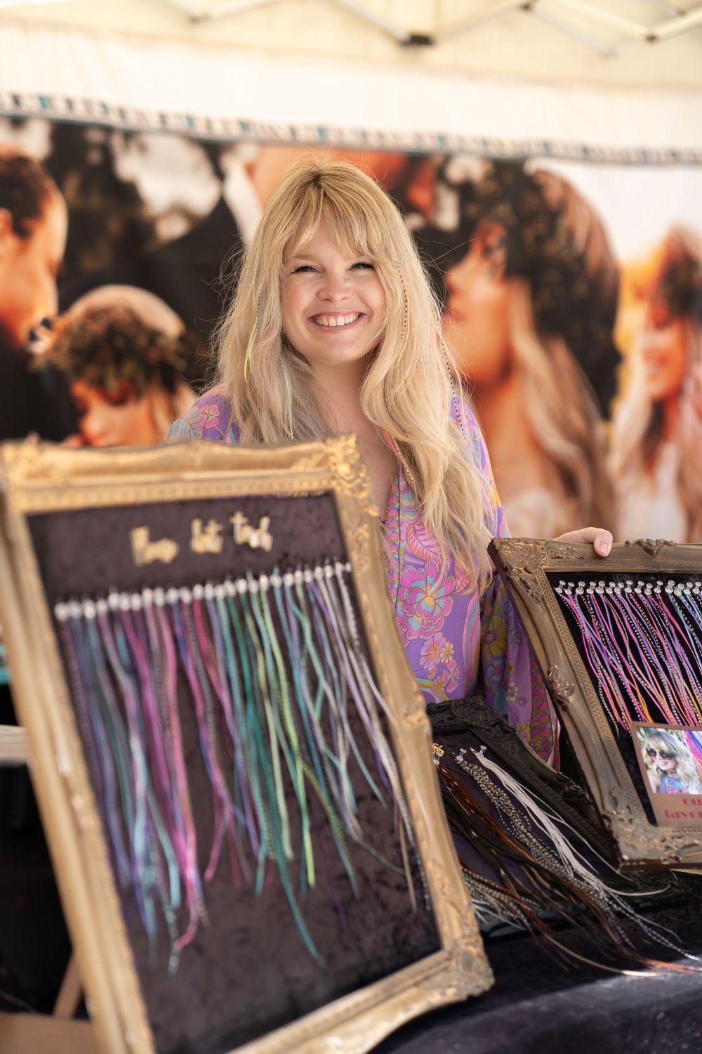 Artisan vendor displaying handmade accessories at an outdoor market booth.