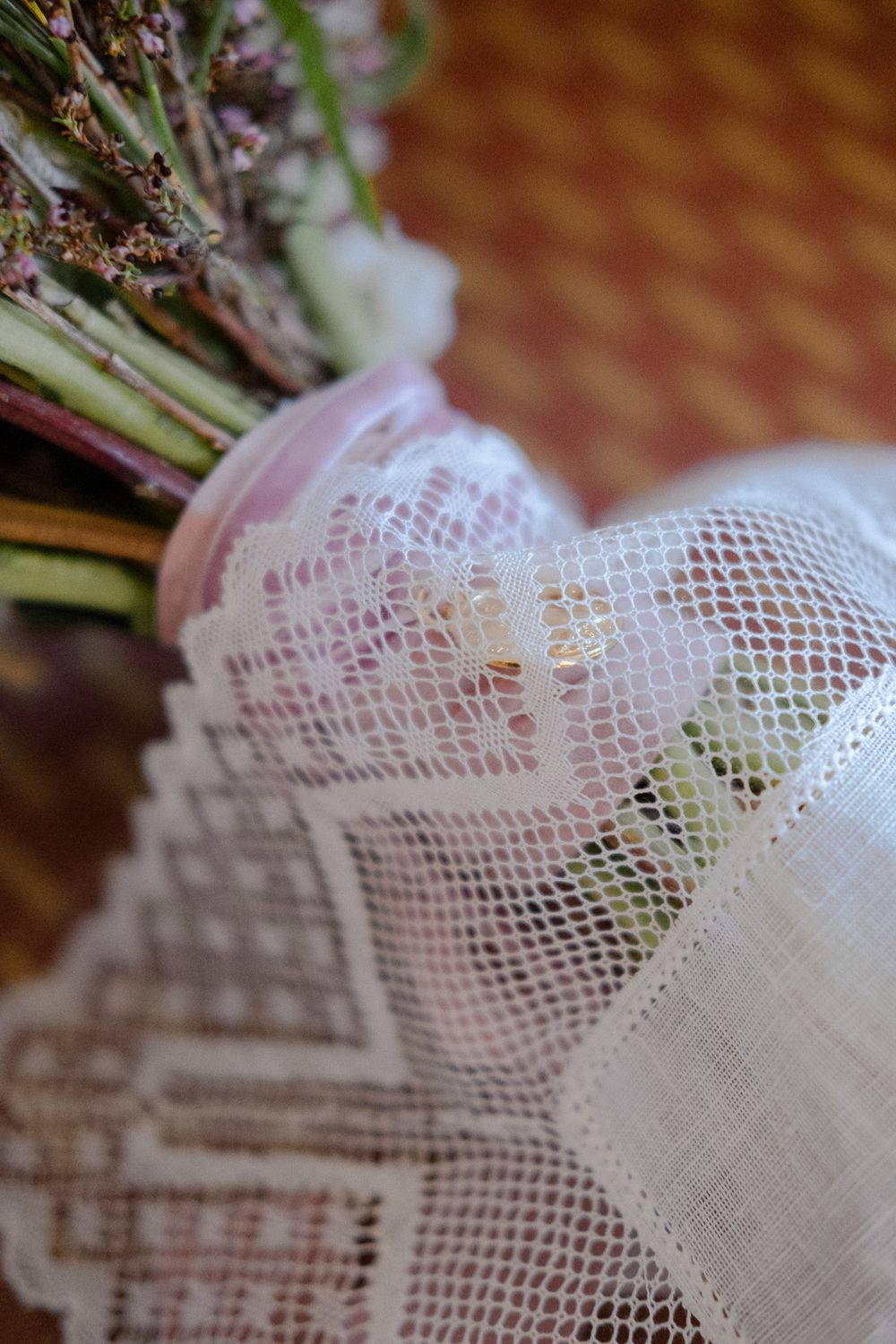 Wedding bouquet wrapped in delicate lace detailing.