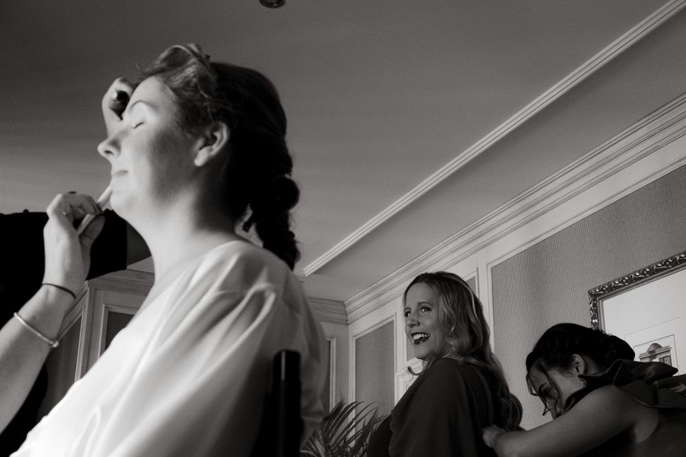 Black and white candid scene of wedding preparation moments.