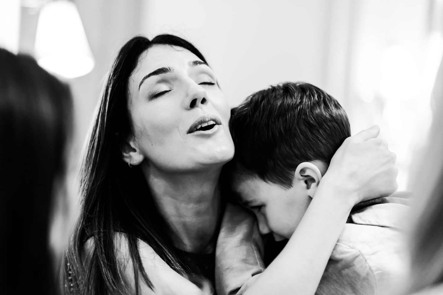 Black and white intimate portrait of mother and child sharing a tender emotional moment together.