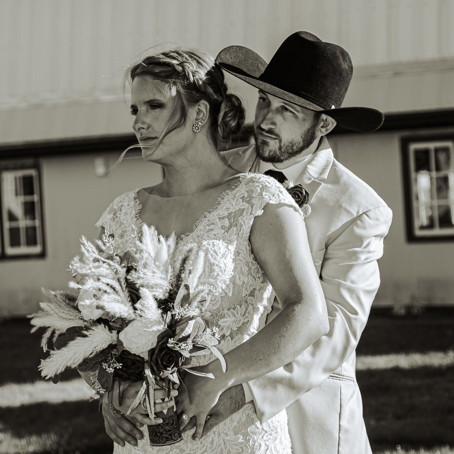 Black and white wedding photo showing a couple in western attire with the bride holding a bouquet.