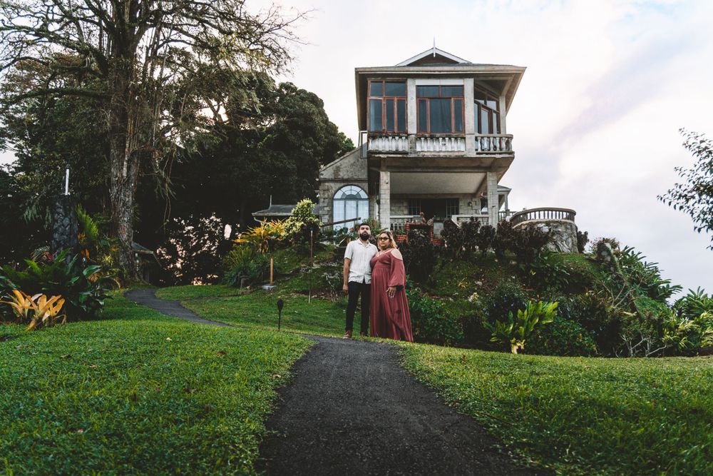 A couple stands on a path leading to Mahogany Ridge surrounded by lush greenery in Trinidad.