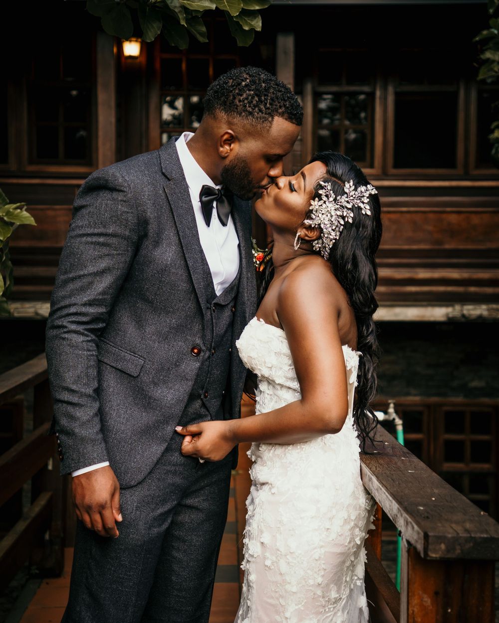 A romantic moment captured between newlyweds on a wooden deck.