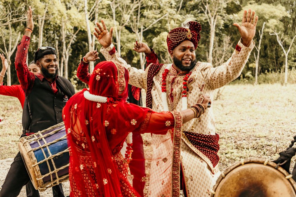 Wedding celebration with traditional drums and dancing in vibrant red cultural attire.