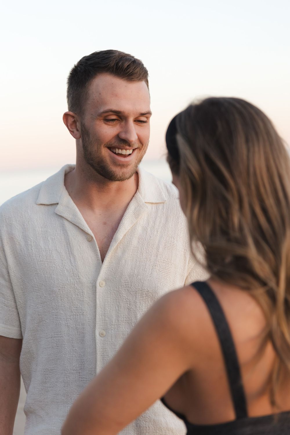 A couple shares a happy moment together on the beach at sunset.