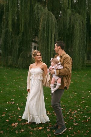 Playful outdoor photo sequence with white dress and brown jacket against willow trees.