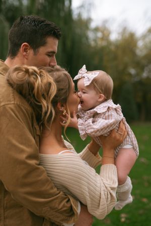 Tender family moment captured outdoors with soft autumn lighting.