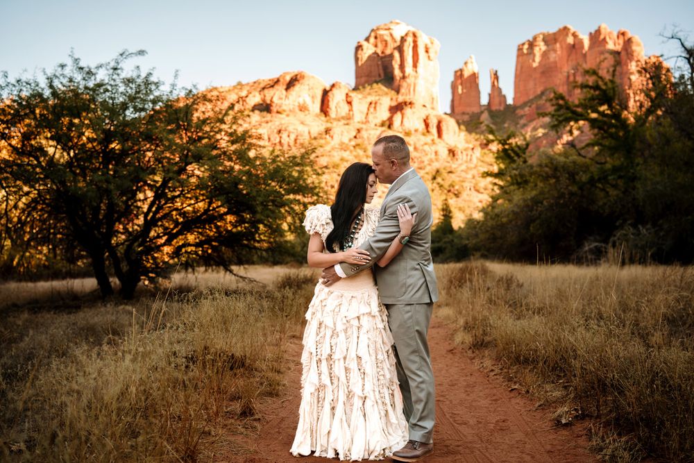 Sunset wedding portrait with majestic Sedona red rock cliffs in background.