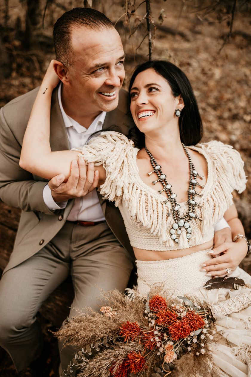 A tender moment captured between a couple in western-themed wedding attire.