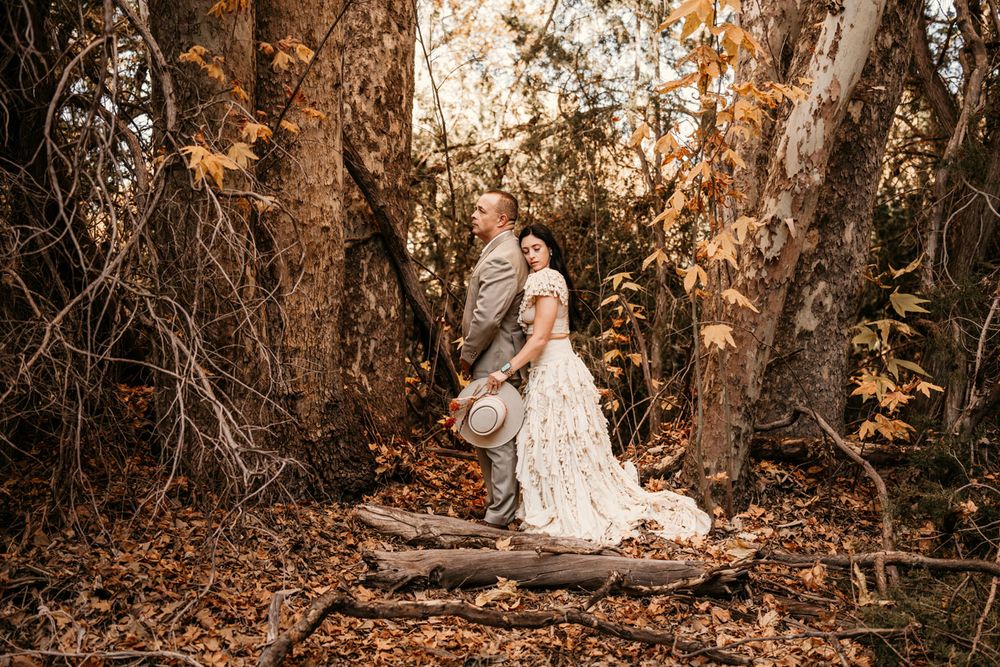 A romantic western-themed photoshoot in an autumn forest setting.