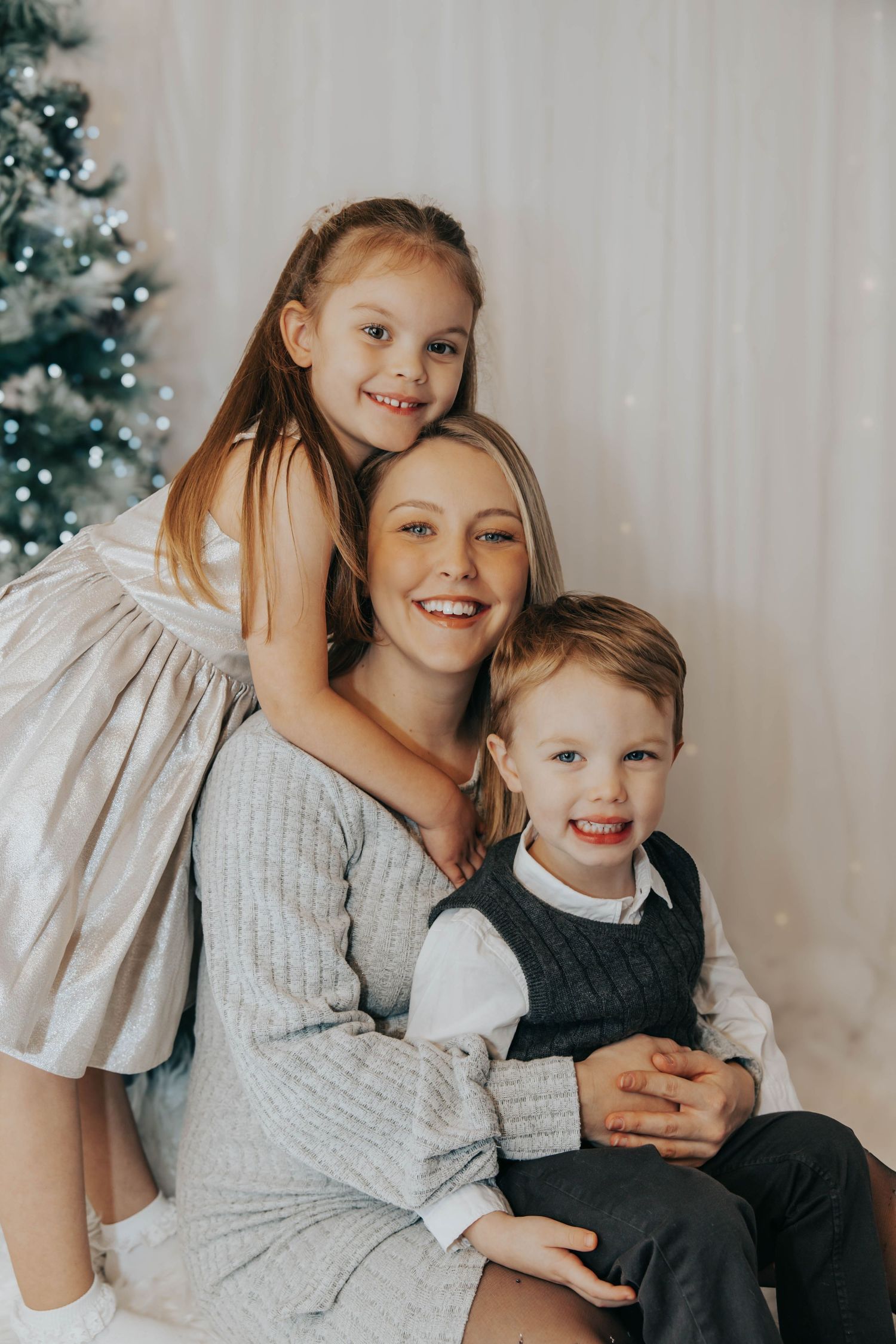 Family poses together in coordinated outfits for Christmas studio portrait.