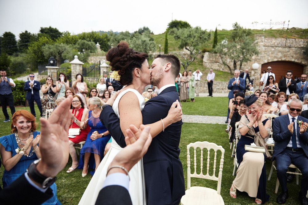 una coppia di sposi che si bacia dopo il fatidico sì, una fotografia perfetta e di qualità che racconta uno dei momenti più emozionanti