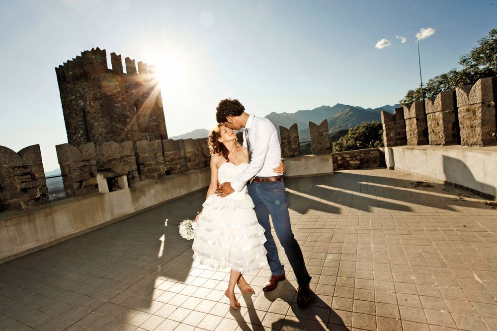 Una fotografia dinamica di una coppia di sposi su una prestigiosa location, un castello con merlatura medievale